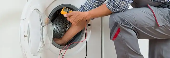 Dryer repair technician inspecting and repairing a clothes dryer in Cincinnati, OH