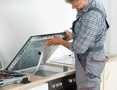 Appliance repair technician installing a built-in cooktop in Cincinnati, OH