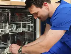 Dishwasher repair technician inspecting and servicing an open dishwasher in Cincinnati, OH