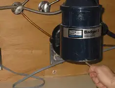Garbage disposal repair technician tightening the mounting ring under a sink in Cincinnati, OH
