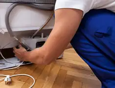 Appliance repair technician fixing refrigerator water line and connections in Cincinnati, OH
