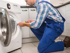 Washing machine repair technician servicing a front-load washer in Cincinnati, OH