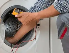 Washing machine repair technician testing a front-load washer with diagnostic tools in Cincinnati, OH