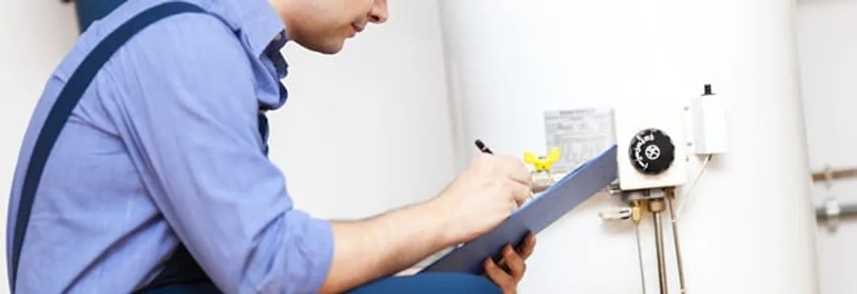 Water heater repair technician inspecting the unit and recording service notes in Cincinnati, OH