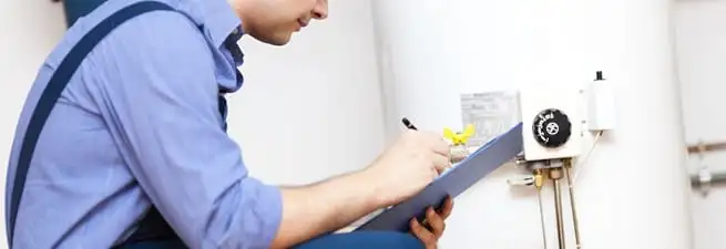 Water heater repair technician inspecting the unit and recording service notes in Cincinnati, OH