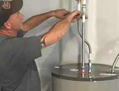 Water heater repair technician tightening supply line connections in Cincinnati, OH