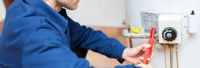 Water heater repair technician adjusting the temperature control and gas valve in Cincinnati, OH